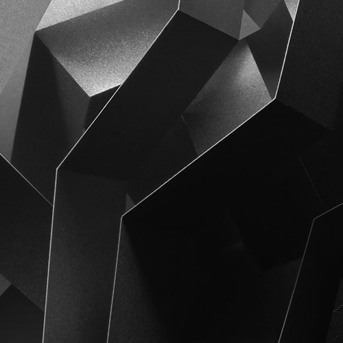 Abstract image of angular, geometric shapes in varying shades of black and gray, creating a sharp, three-dimensional effect with strong contrasts and shadows.